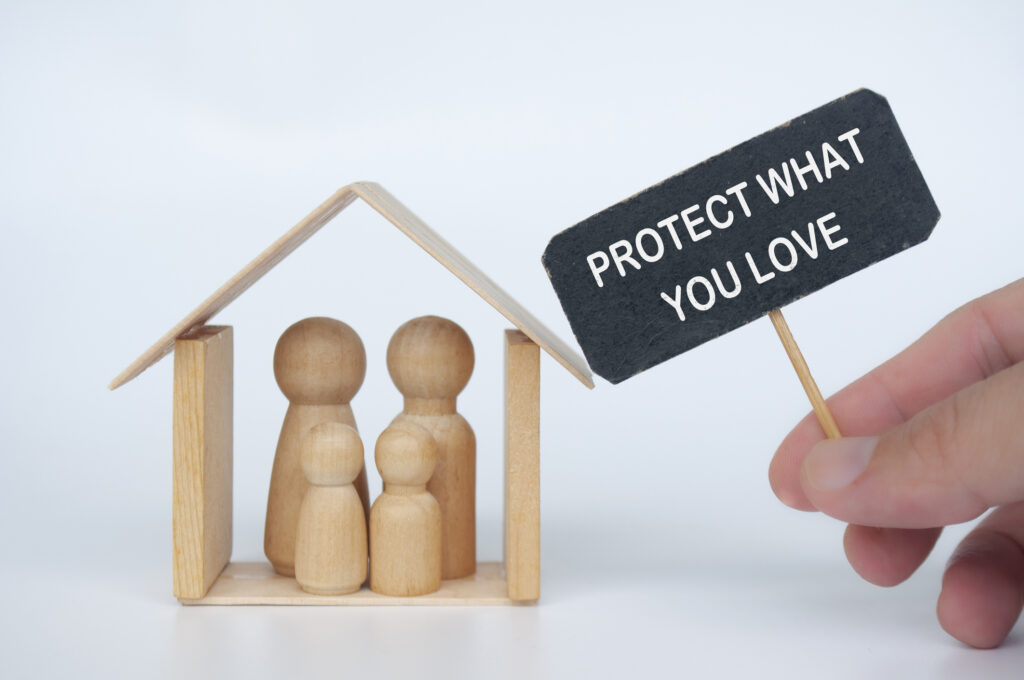 Protect what you love text on black signage with family figure